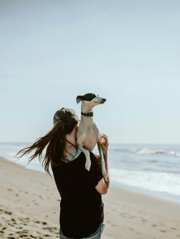 woman in black tank top and black pants standing on beach shore during daytime