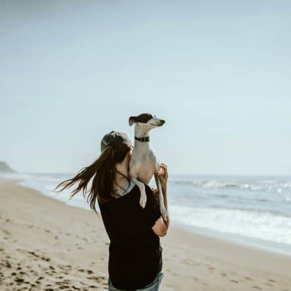 woman in black tank top and black pants standing on beach shore during daytime