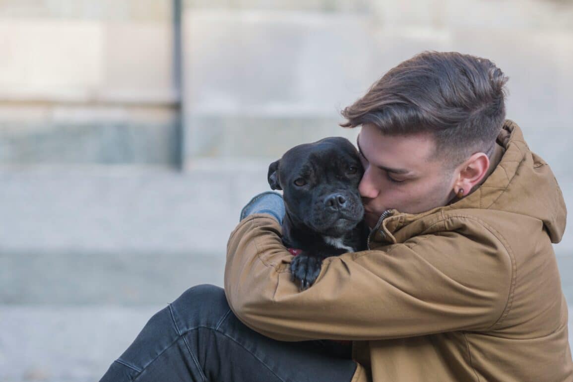 man hugging his dog outside