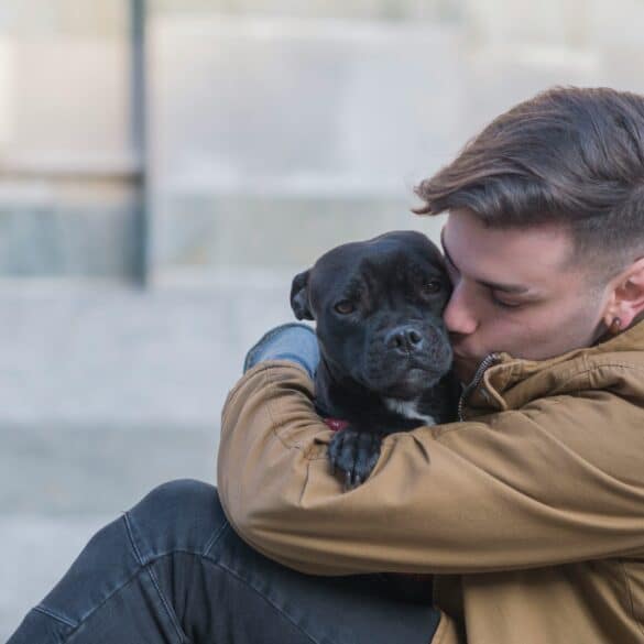 man hugging his dog outside