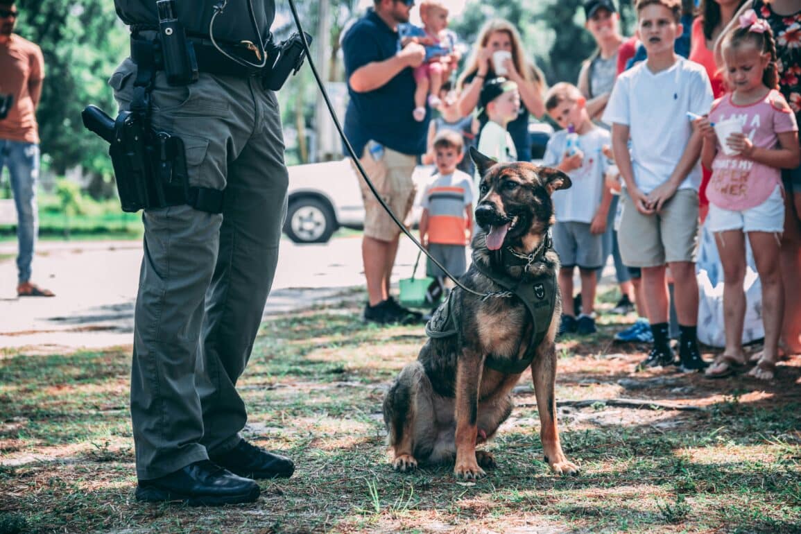 police dog and officer standing in front of a crowd